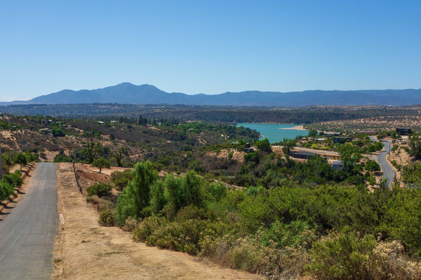 Vista del lago y los cerros desde un camino de parcelas en la V Región